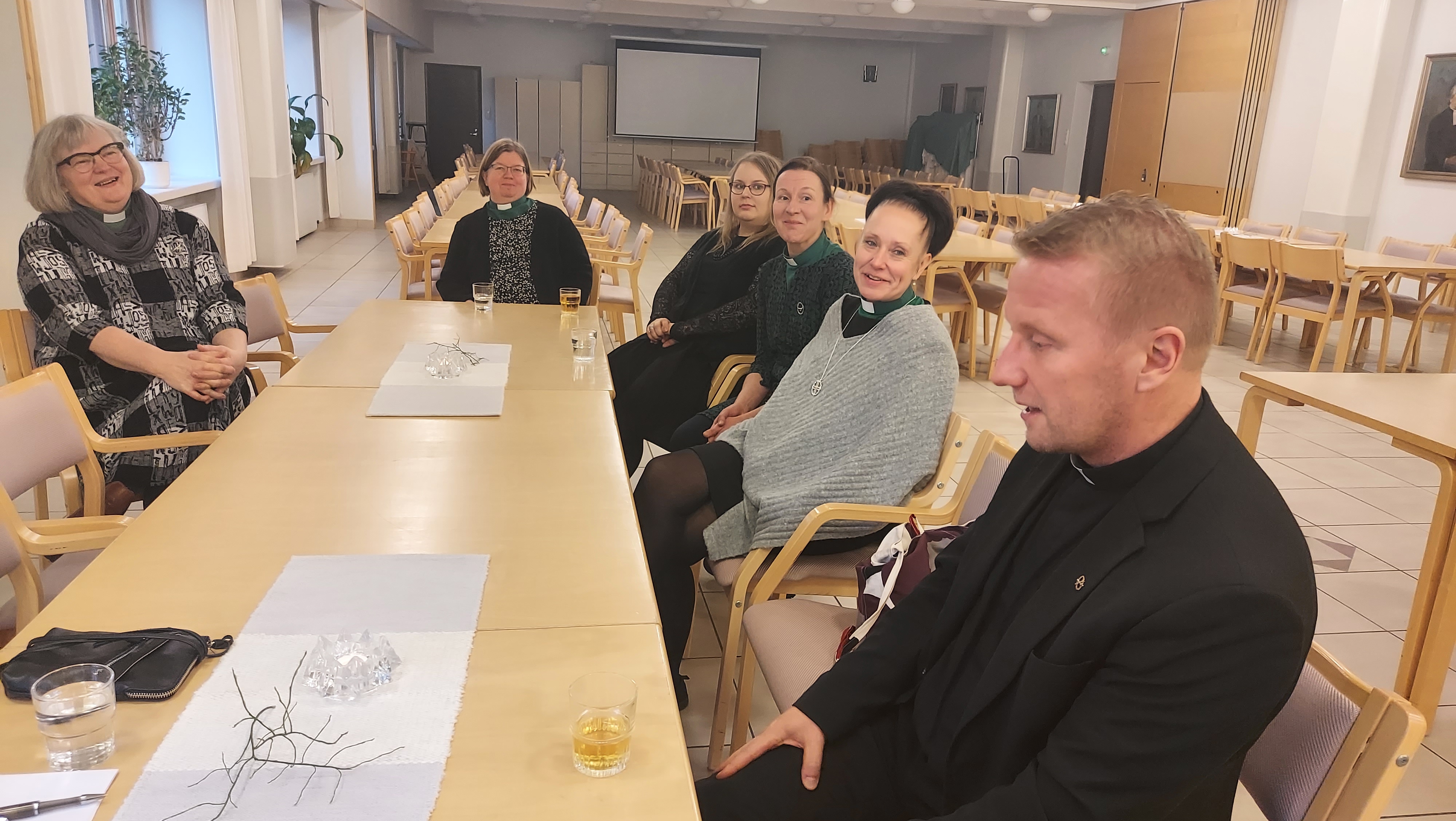Ihmisiä pöydän ääressä.