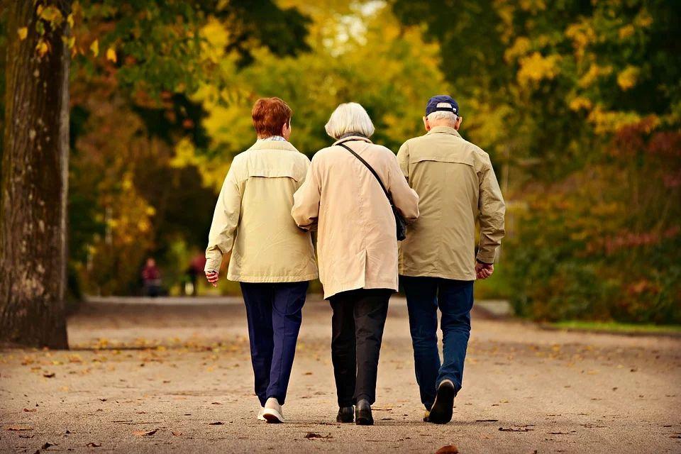 kolme vanhusta kävelee vierekkäin