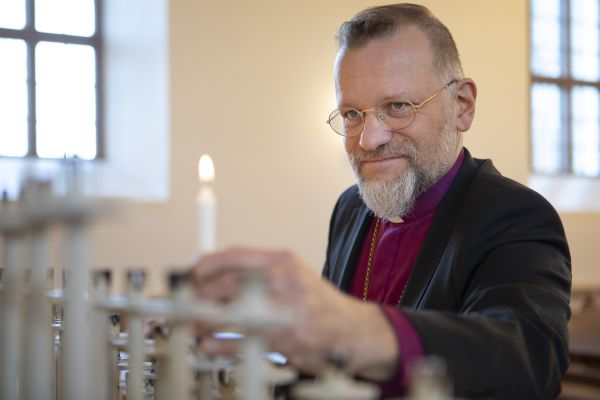 Kuopion hiippakunnan piispa sytyttää rukouskynttilän.