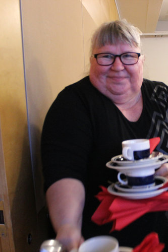 Eeva kantaa lisäkuppeja sermillä jaetun salin toiseen päähän.