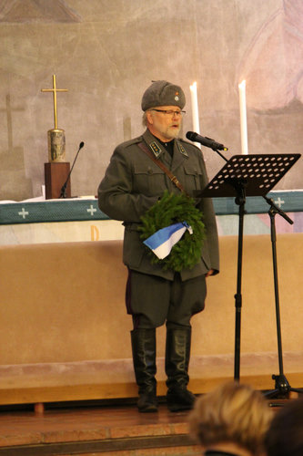 Armeijan harmaissa mikrofoniin puhumassa kappalainen Kari Iivarinen.