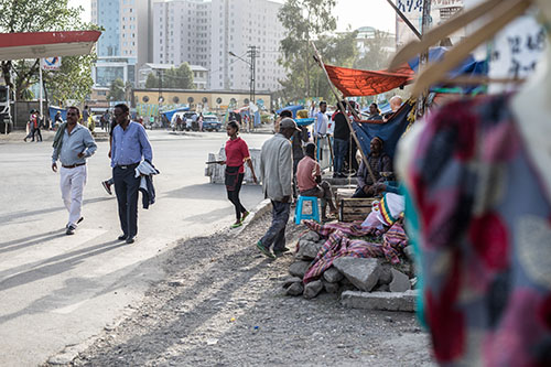 Ihmisiä Addis Abeban kadulla myyntikojujen läheisyydessä.