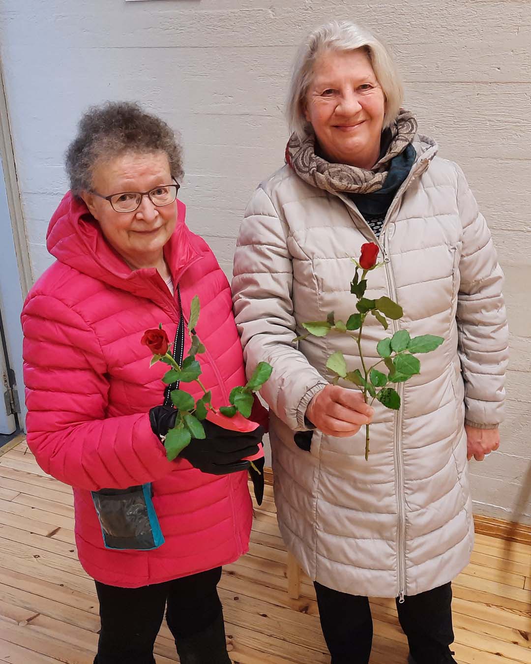 Kaksi naista ruusut käsissään.
